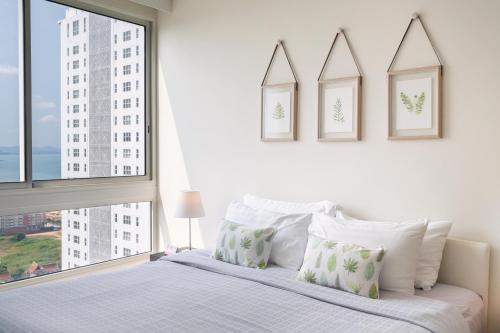 a bedroom with a white bed and a large window at 2BR Family Condo - Veranda Pattaya - Beachfront in Na Jomtien