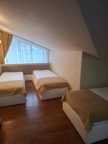 a bedroom with two beds and a large window at Апартаменти Вілла Гор in Bukovel