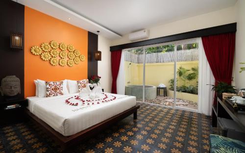 a bedroom with a large bed and a large window at Indochine Sanctuary Hotel in Siem Reap