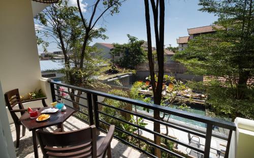 a balcony with a table and chairs and a view at Indochine Sanctuary Hotel in Siem Reap