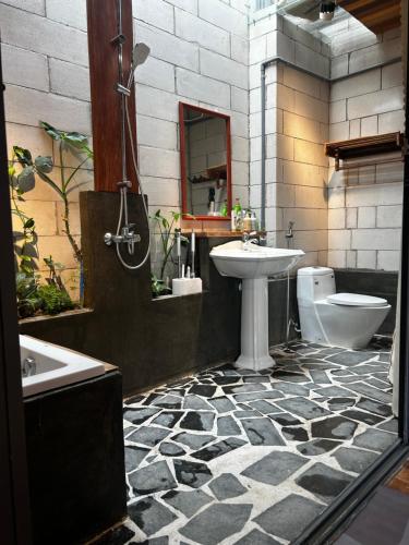 a black and white bathroom with a sink and a toilet at Hong Ly House in Vĩnh Hy