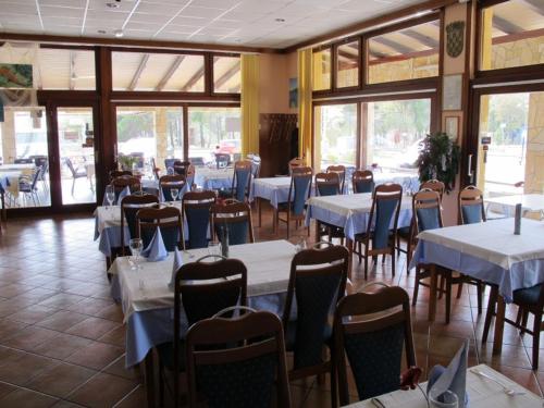een eetkamer met tafels en stoelen en een tafeltennistafel bij Apartments and Rooms Degenija in Starigrad-Paklenica