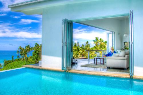 a villa with a swimming pool and the ocean at Vacala Bay Resort in Matei