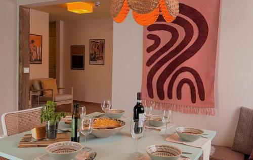 a dining room table with wine glasses and a painting at 2 Bedroom Nice Apartment In Glemmingebro in Glemminge