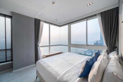 a bedroom with a large bed with a large window at Large 3BR Veranda Pattaya Direct Beach Access in Jomtien Beach