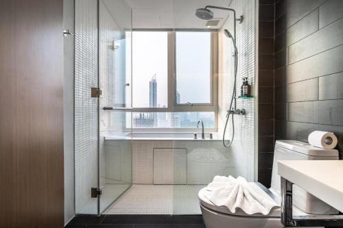 a bathroom with a shower and a toilet and a window at Large 3BR Veranda Pattaya Direct Beach Access in Jomtien Beach