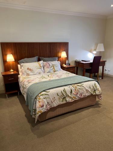 a bedroom with a large bed and a desk at The Astra Broken Hill in Broken Hill