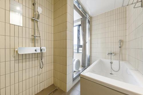 a bathroom with a tub and a shower and a sink at Daegu Hound Hotel Dongchon Amusement Park in Daegu