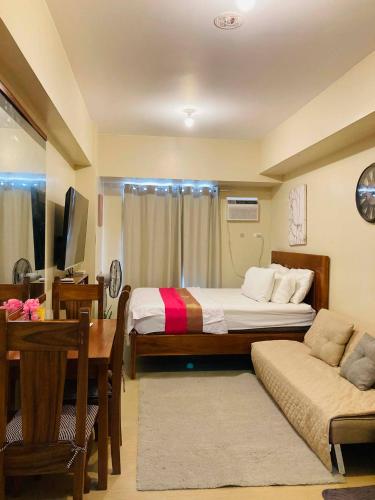 a room with two beds and a table and a desk at 711 Tower 3 Avida Atria Iloilo Comfy Cozy Central in Iloilo City