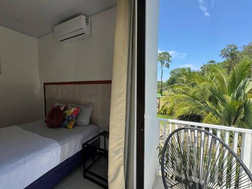 a bedroom with a bed and a balcony at Butterfly House - Centric 2BR with shared pool in Puerto Viejo