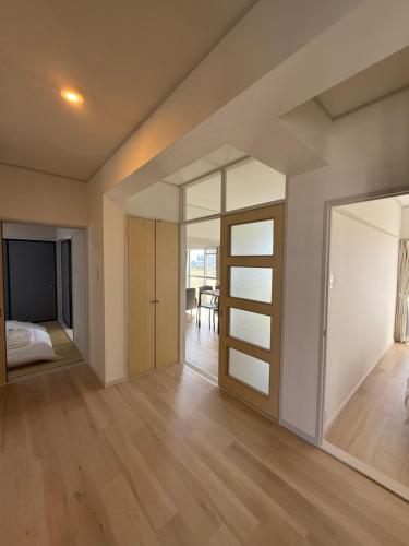 an open living room with sliding glass doors and a bedroom at OtowaBase in Kofu