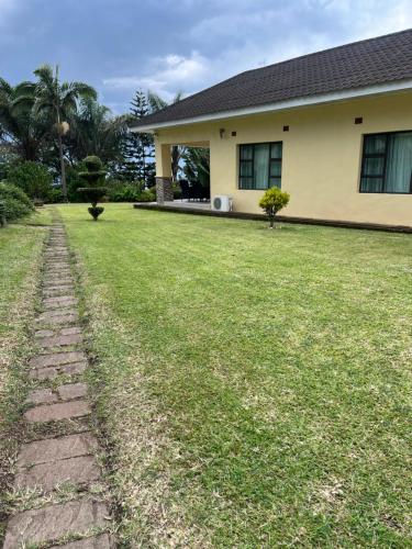 a house with a grass yard in front of it at Lonehill Ridge in Blantyre