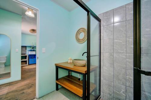 a bathroom with a shower and a wooden table at Casa Caribe Azul - Playa Negra 2BR with AC and pool in Puerto Viejo