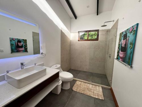 a bathroom with a sink and a toilet and a shower at Sharka House - Playa Negra 2BR with pool & AC in Puerto Viejo