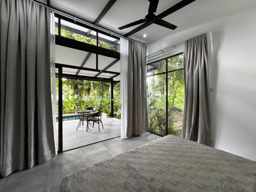 a bedroom with a bed and sliding glass doors at Sharka House - Playa Negra 2BR with pool & AC in Puerto Viejo