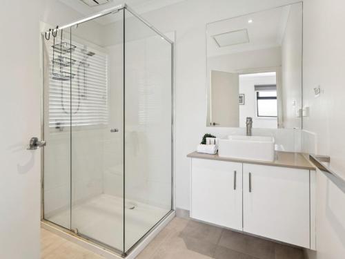 a bathroom with a glass shower and a sink at Azura on Gordon in Mornington