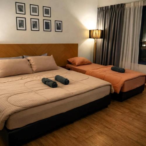 two beds sitting next to each other in a room at Wafiq Studio in Kota Bharu