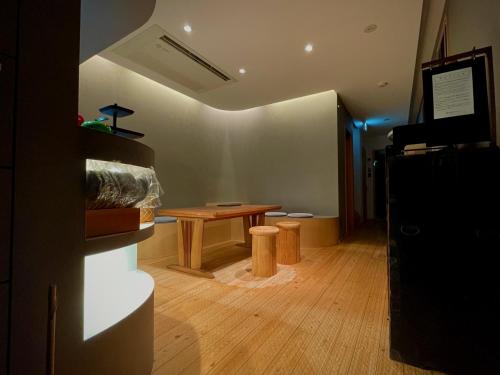 a room with a table and stools in a room at hatago STAY Shinmachi in Nakatsugawa