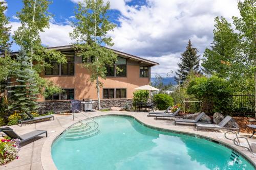 a swimming pool in front of a house at Aspenwood - CoralTree Residence Collection in Snowmass Village