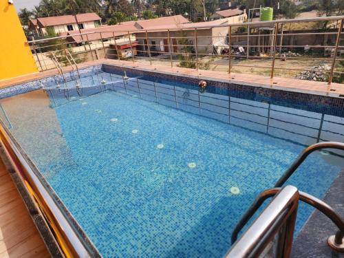 a large swimming pool on top of a building at Paromita inn in Tajpur