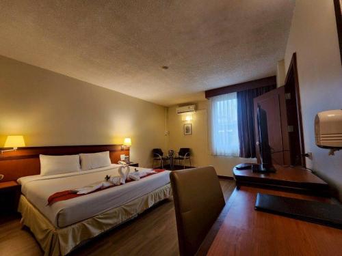 a hotel room with a bed and a television at Hatyai Golden Crown Hotel in Hat Yai