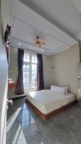 a bedroom with a large white bed and a window at Sentosa Lodge in Padang