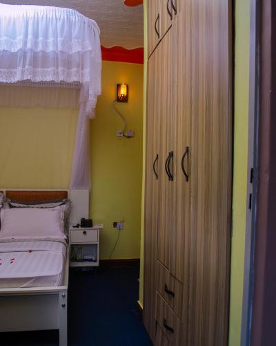a bedroom with a bed and a wooden door at Meltonia Luxury Inn in Busia