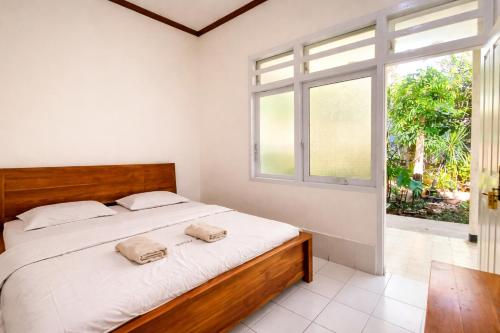 a bedroom with a large bed and a window at Bajo Hotel in Labuan Bajo
