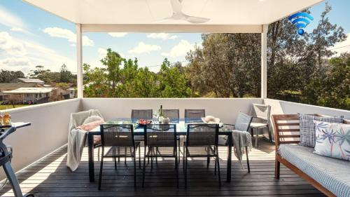 a patio with a table and chairs on a deck at The Art House in Culburra Beach