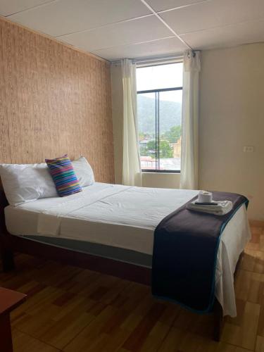 a bedroom with a large bed with a window at Irigoin Hospedaje in Nueva Cajamarca