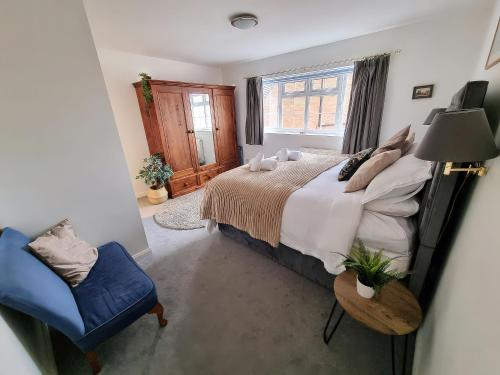 a bedroom with a bed and a chair and a window at 3 Leycester Court in Warwick