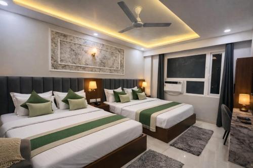 a hotel room with two beds and a ceiling fan at Hotel Royal Dot, Haridwar in Haridwār