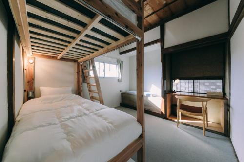 a bedroom with a bunk bed and a desk at Public Guest House in Karuizawa