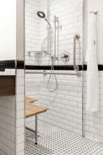 a shower in a bathroom with white subway tiles at Archer Hotel New York in New York