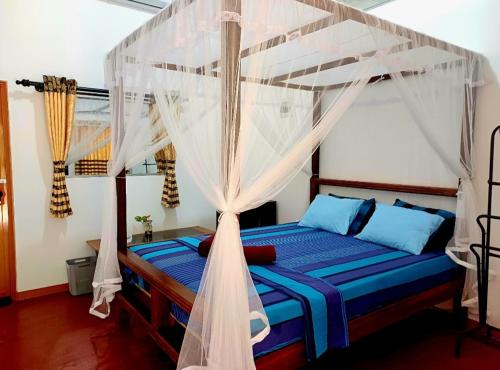 a bedroom with a bed with a canopy at Turtle Island Cabana in Tangalle