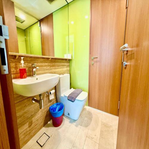 a bathroom with a sink and a toilet and a mirror at Sky klcc by DMK luxury suites Apartment in Kuala Lumpur