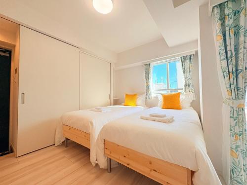 two beds in a bedroom with a window at REGNO COMFORT ASAKUSA Ⅳ in Tokyo
