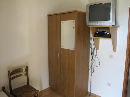 a television sitting on top of a wooden cabinet at Apartments and Rooms Degenija in Starigrad-Paklenica