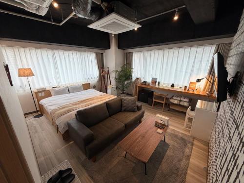 a bedroom with a bed and a couch and a desk at TOKYO-W-INN Asakusa in Tokyo