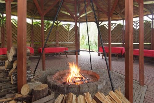 a fire pit in a pavilion with red benches at Motel Paradise in Torzym