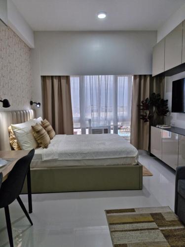a bedroom with a bed and a large window at WeStay by KM Staycations in Dagupan