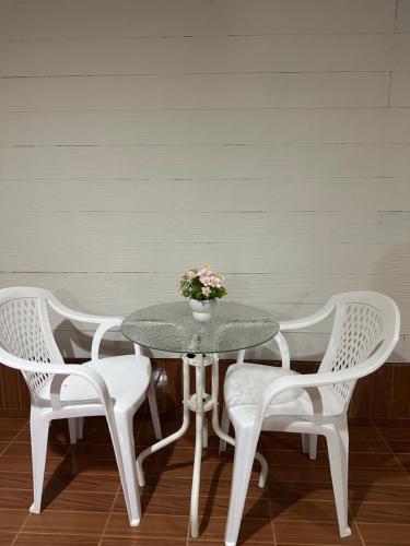 a table with two chairs and a vase with flowers at Ploy Chumpoo Kantiang in Ko Lanta