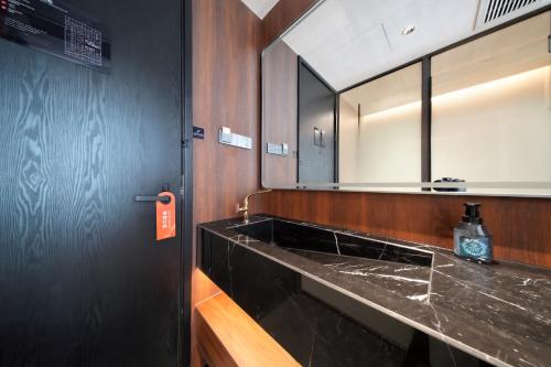 a bathroom with a black sink and a mirror at 上海安鉌蓓斯特酒店国家会展中心虹桥机场店 in Hongqiao Intl