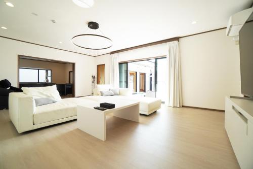 a living room with a white couch and a table at Suma Beach House Ref in Takatorichō