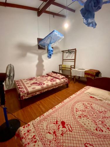 a room with two beds and a fan in it at Fly-In Stay Katunayake in Katunayaka