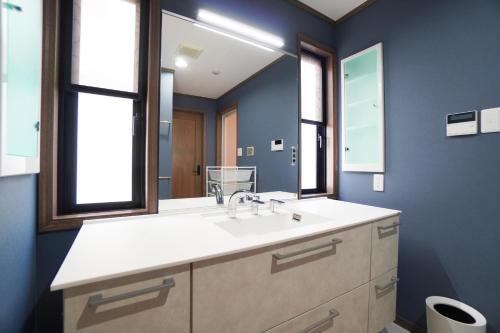 a bathroom with a sink and a mirror at Suma Beach House Ref in Takatorichō