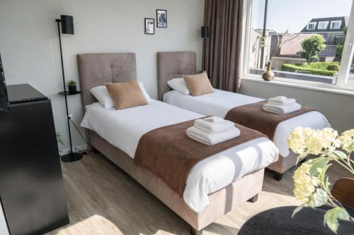 a hotel room with two beds with towels on them at Modern Suite with AC near Breda & Efteling in Raamsdonksveer