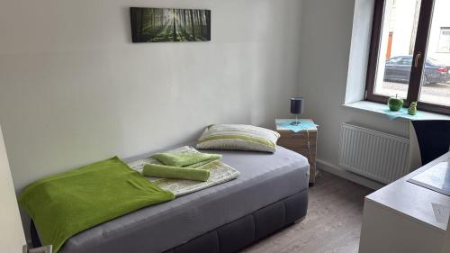 a bedroom with a bed with green pillows on it at Leipzig-in in Leipzig