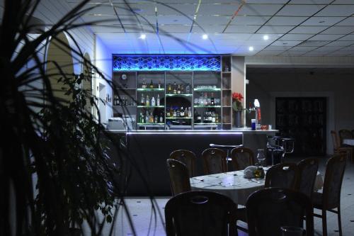 a restaurant with a bar with tables and chairs at Motel Paradise in Torzym