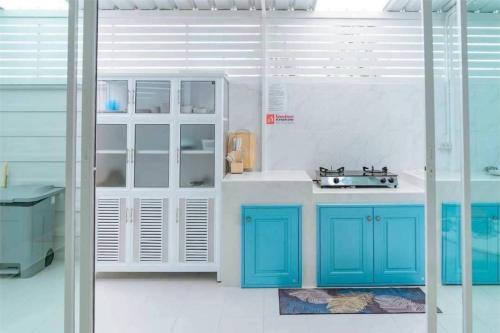 a kitchen with blue cabinets and a sink at Chern Mar Pool Villa Cha-am in Cha Am